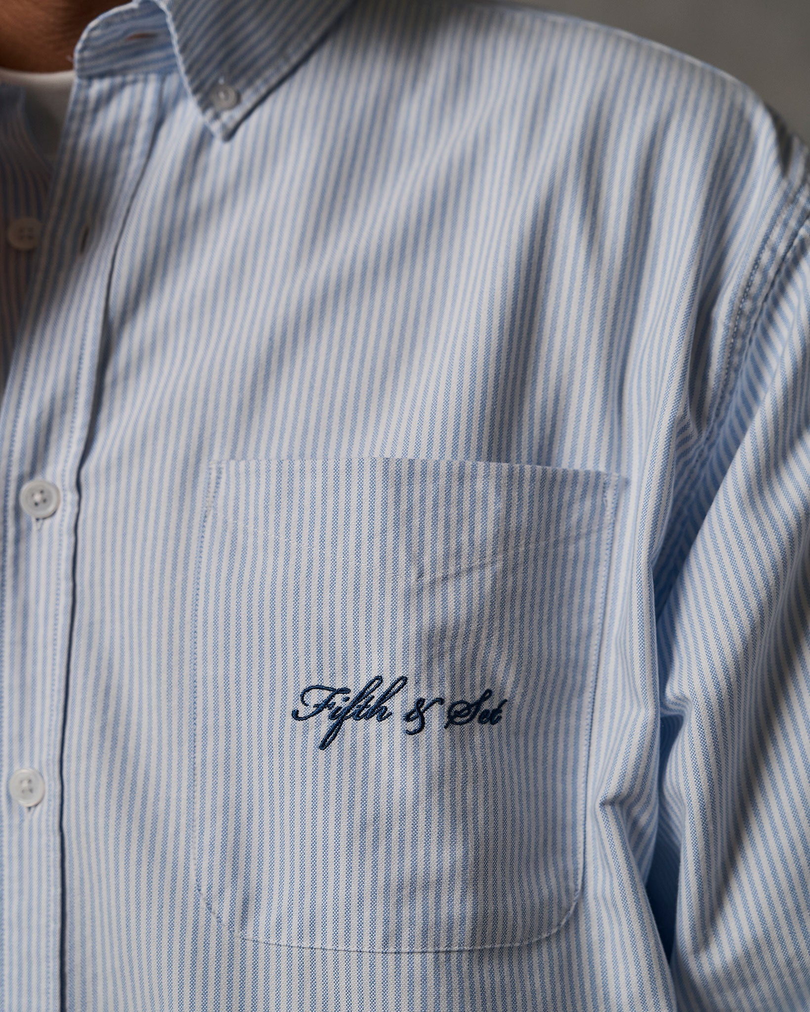 Blue embroidery detail on pocket of shirt