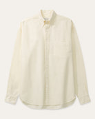 A cream long-sleeve button-down shirt with a single chest pocket, laid flat against a light beige background.