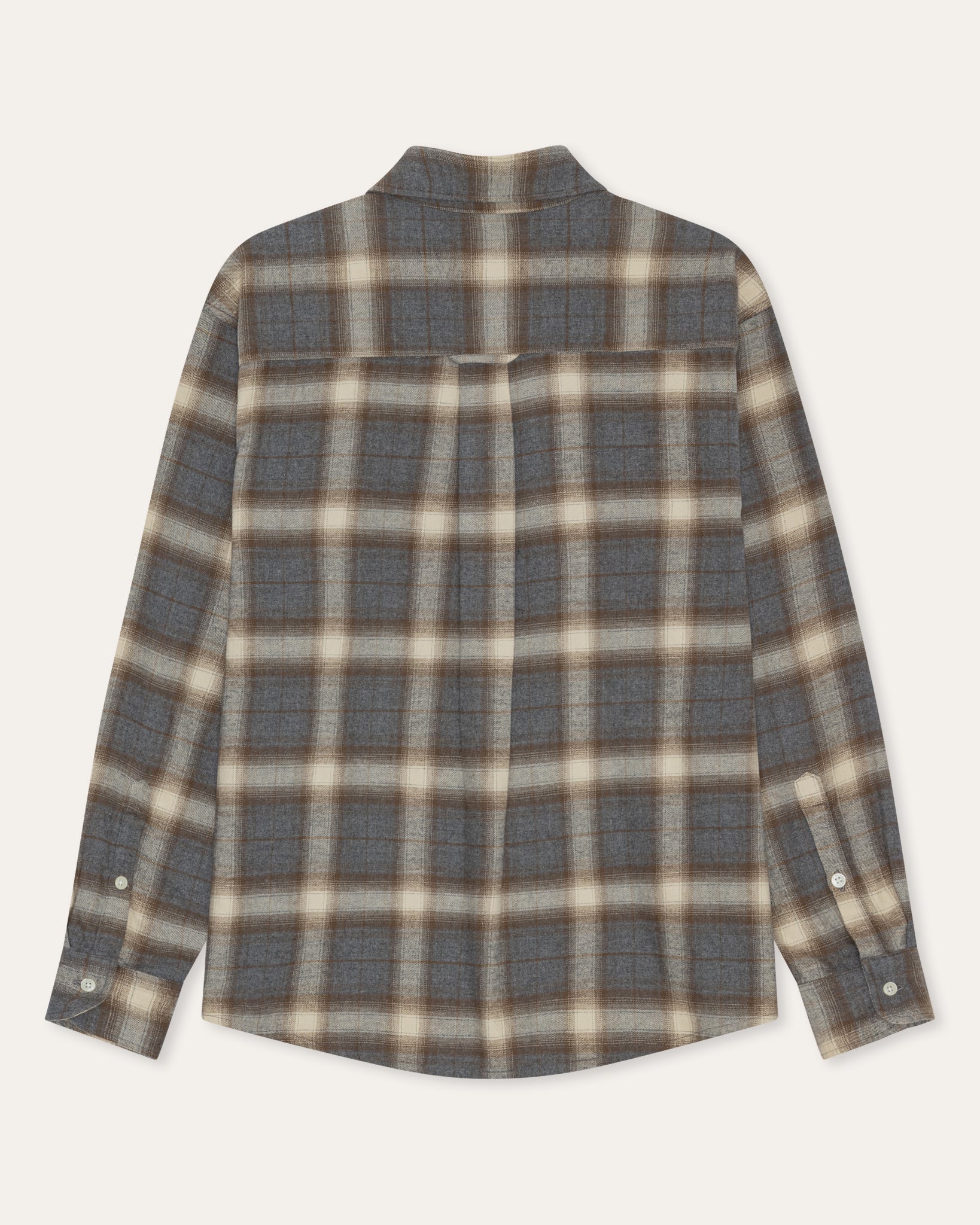 A long-sleeve plaid button-up shirt in a muted gray, beige, and brown tartan pattern, shown flat against a light cream background.