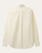 A cream long-sleeve button-down shirt with a single chest pocket, laid flat against a light beige background.