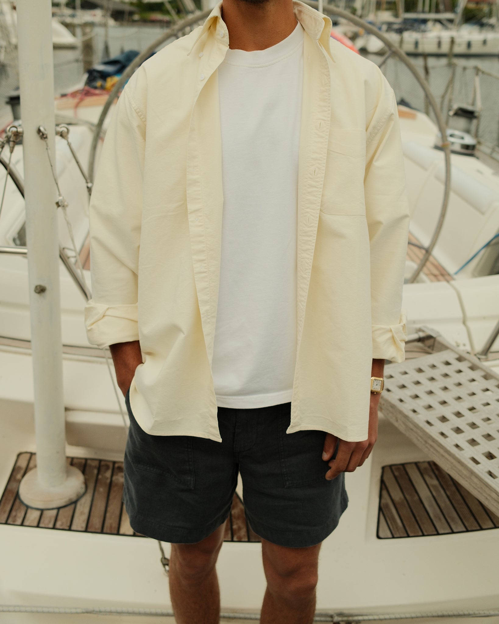 man wearing a cream button down oxford shirt and blue linen shorts
