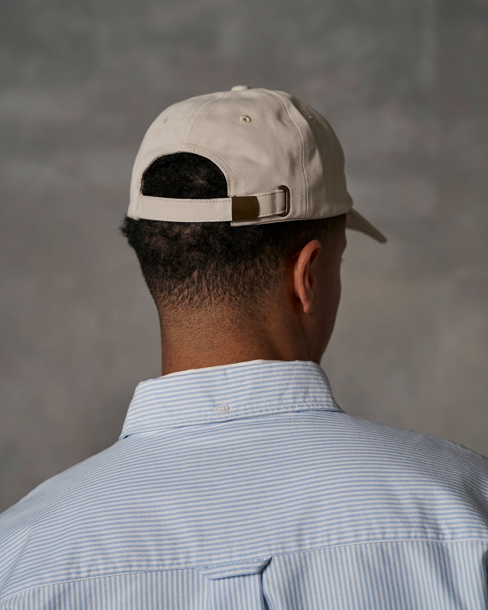 Back of beige cap and oxford shirt