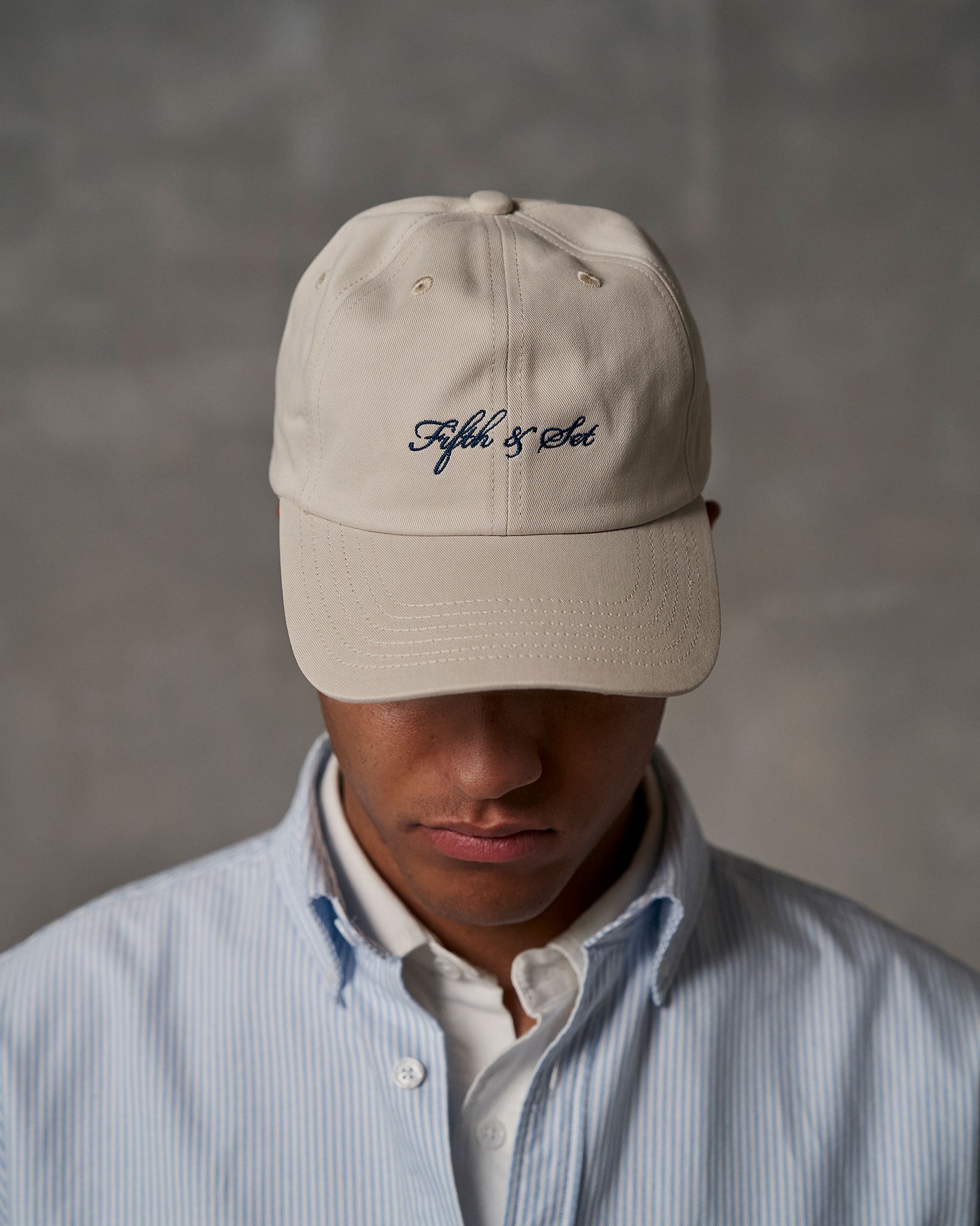 Beige cap with navy embroidered logo on front